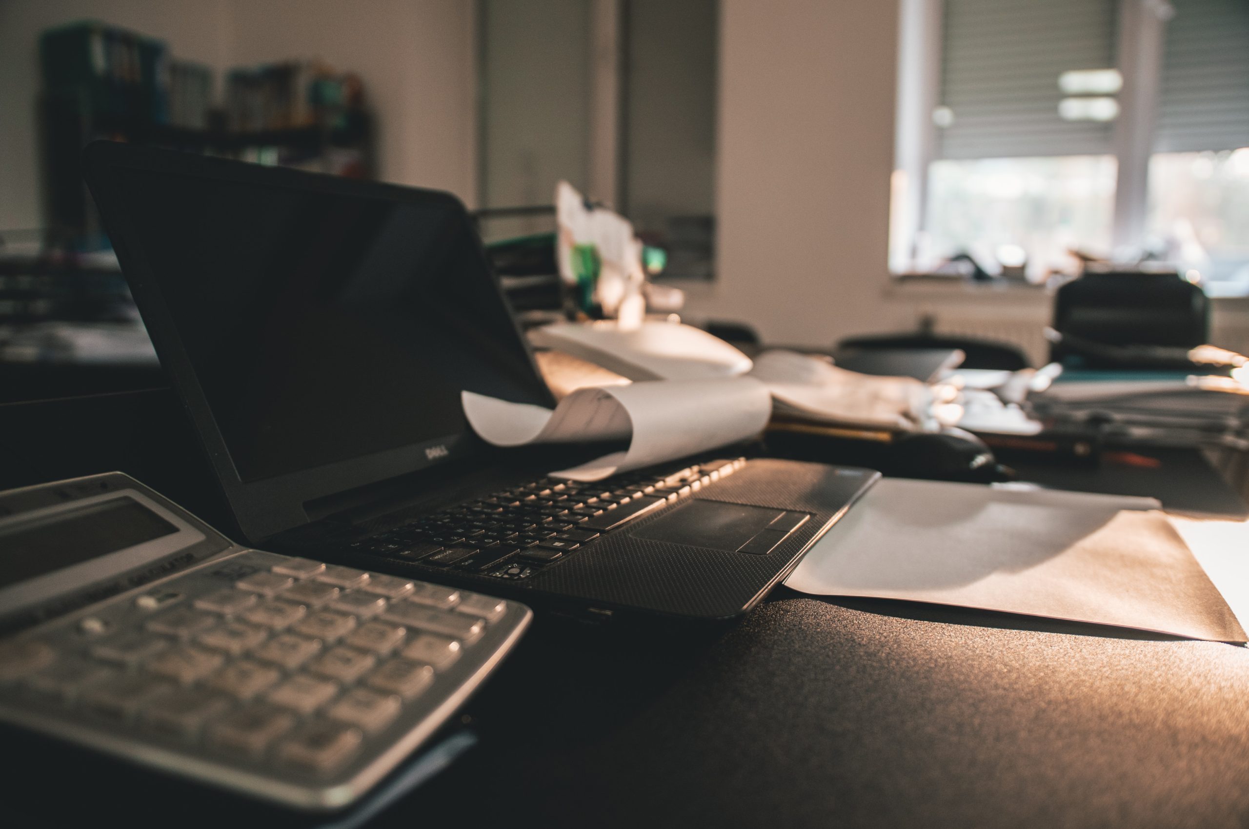 calculator-laptop-sitting-on-dimly-lit-desk-in-office