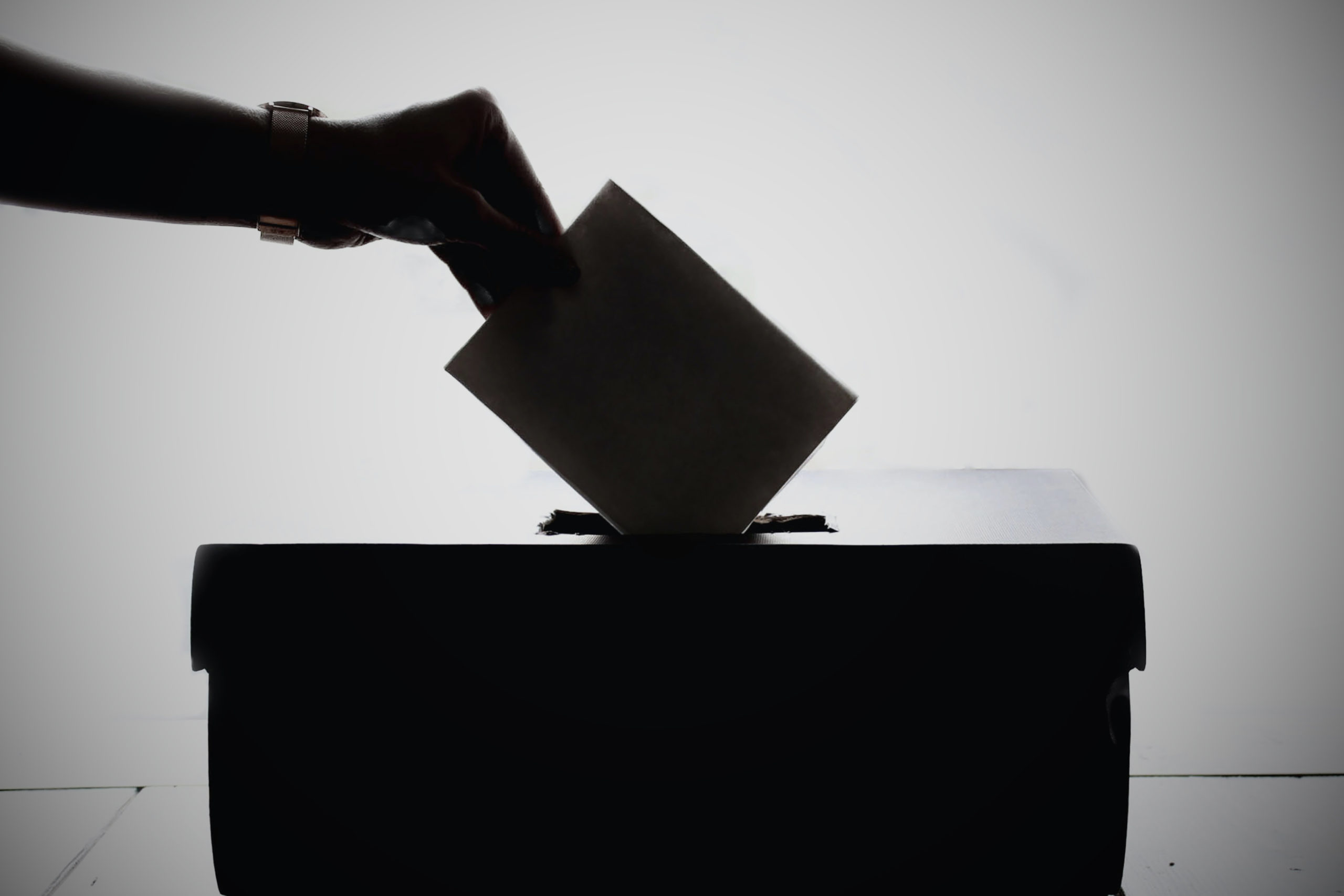hand-putting-paper-in-ballot-box