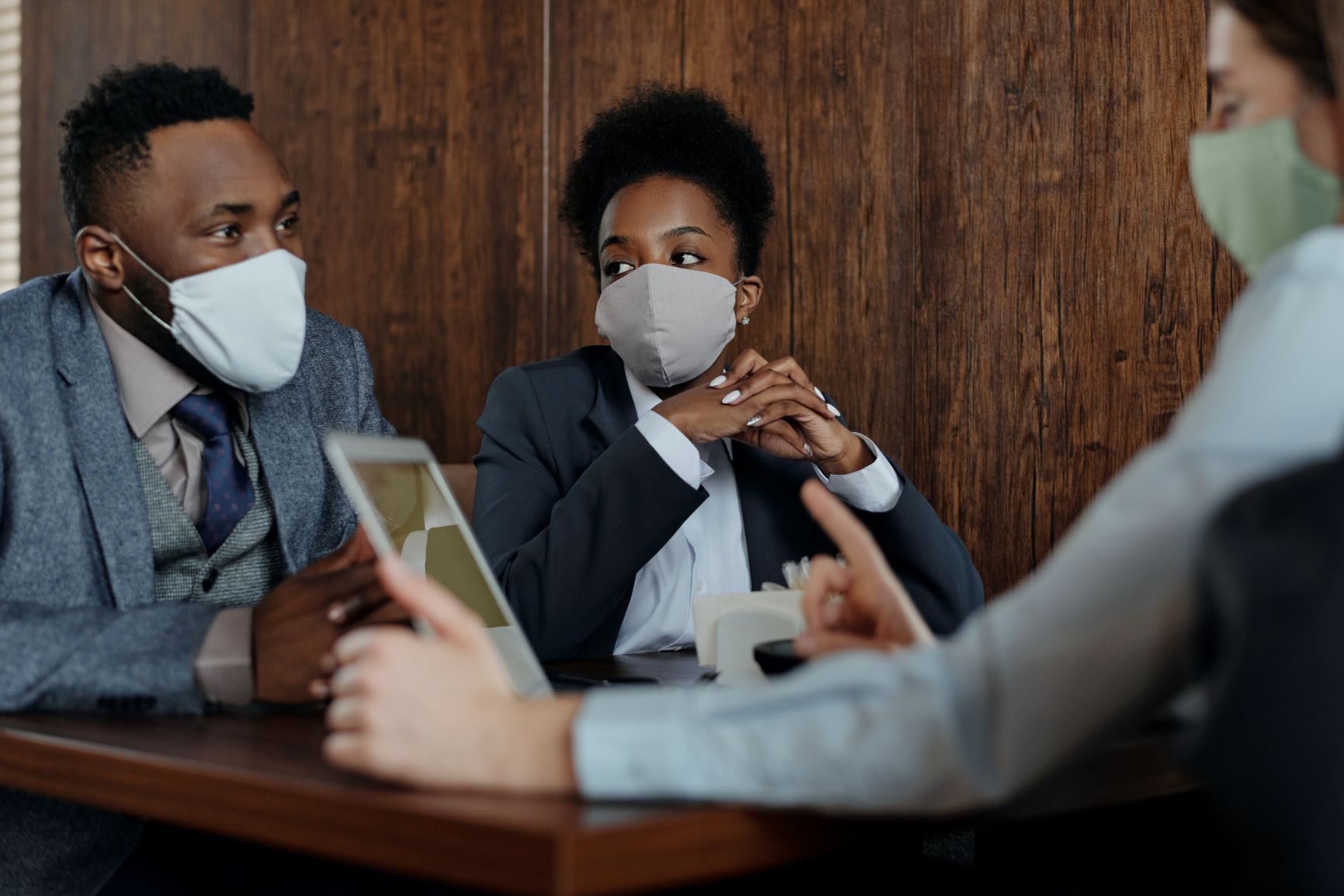 three-business-people-sitting-at-table-wearing-masks