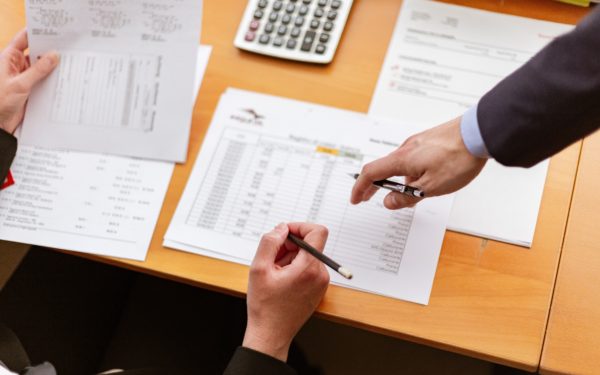desk-with-papers-and-two-mens-hands-pointing