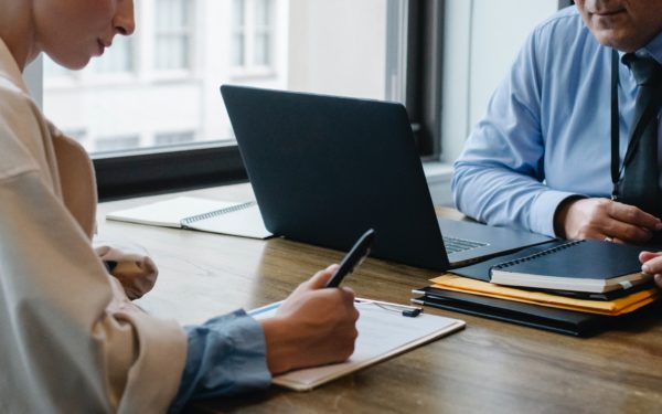 woman-writing-notes-at-desk-during-meeting