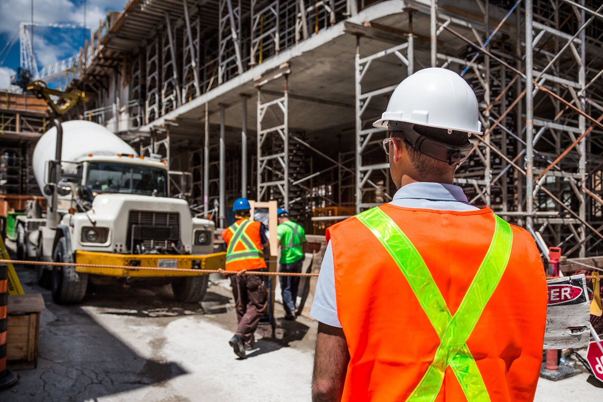 Man-in-hard-hat-with-back-turned-faces-construction-site