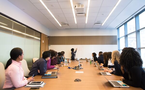 group-of-people-sitting-at-conference-table-watching-presentation