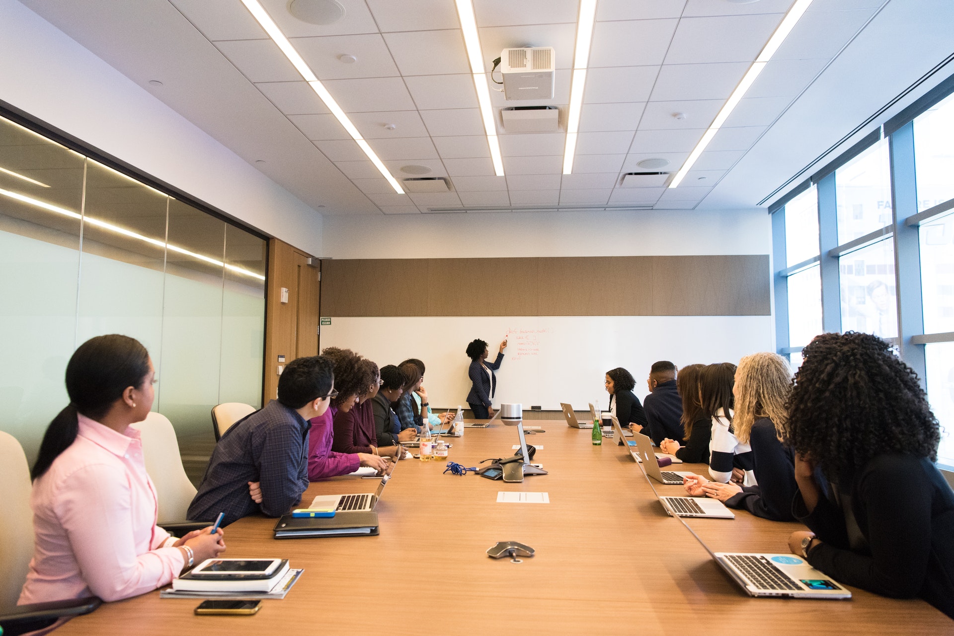 group-of-people-sitting-at-conference-table-watching-presentation