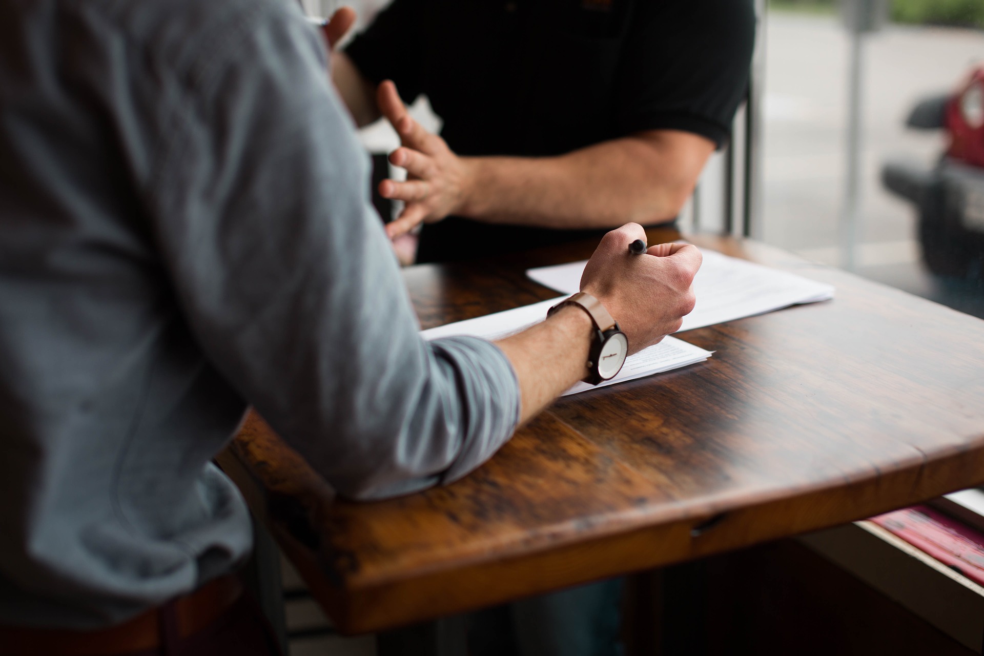 two-people-having-business-meeting-with-papers-on-table