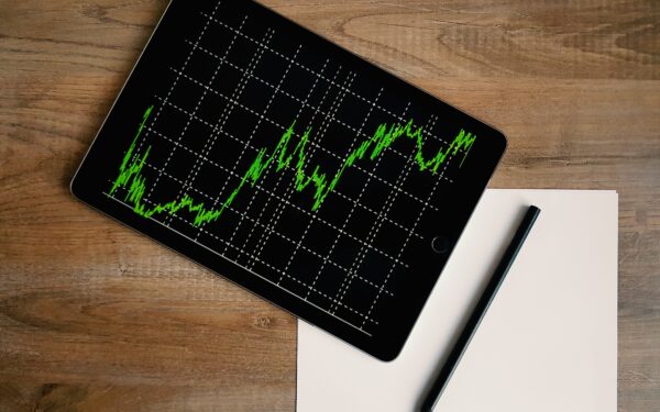 ipad-with-graph-sitting-on-desk-on-top-blank-paper-and-pen