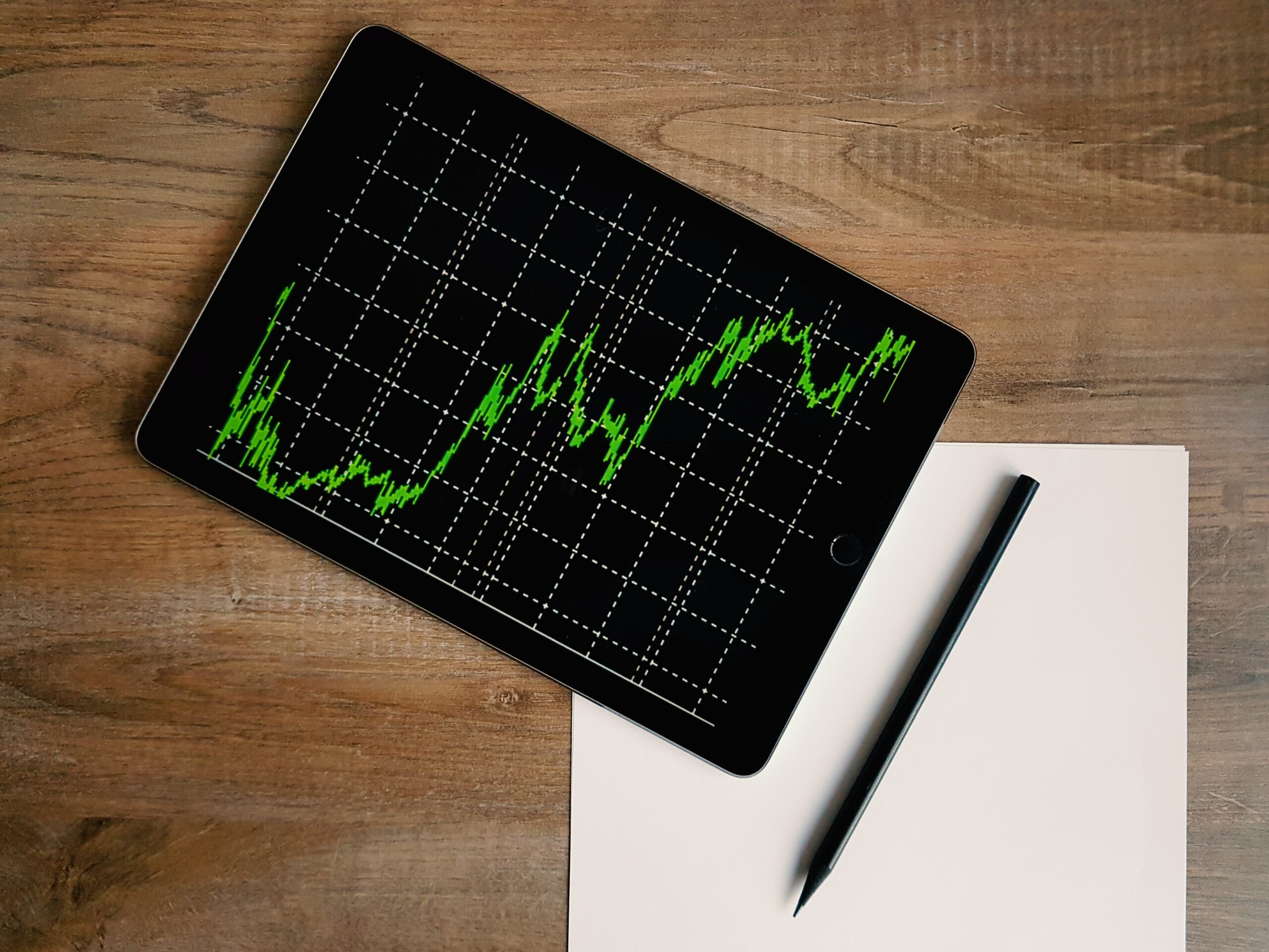 ipad-with-graph-sitting-on-desk-on-top-blank-paper-and-pen