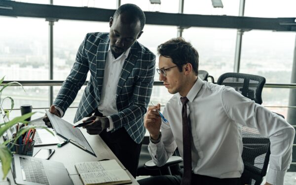Two men in office discussing data