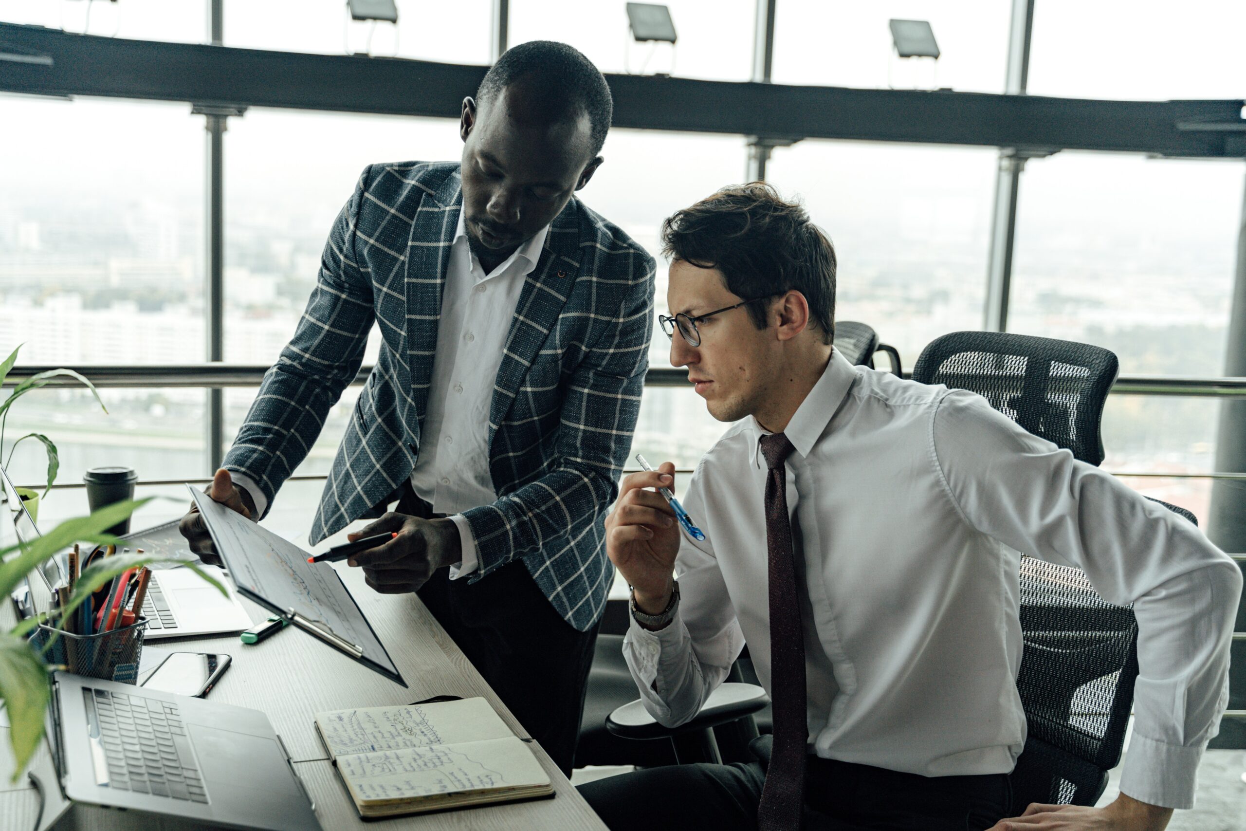 Two men in office discussing data