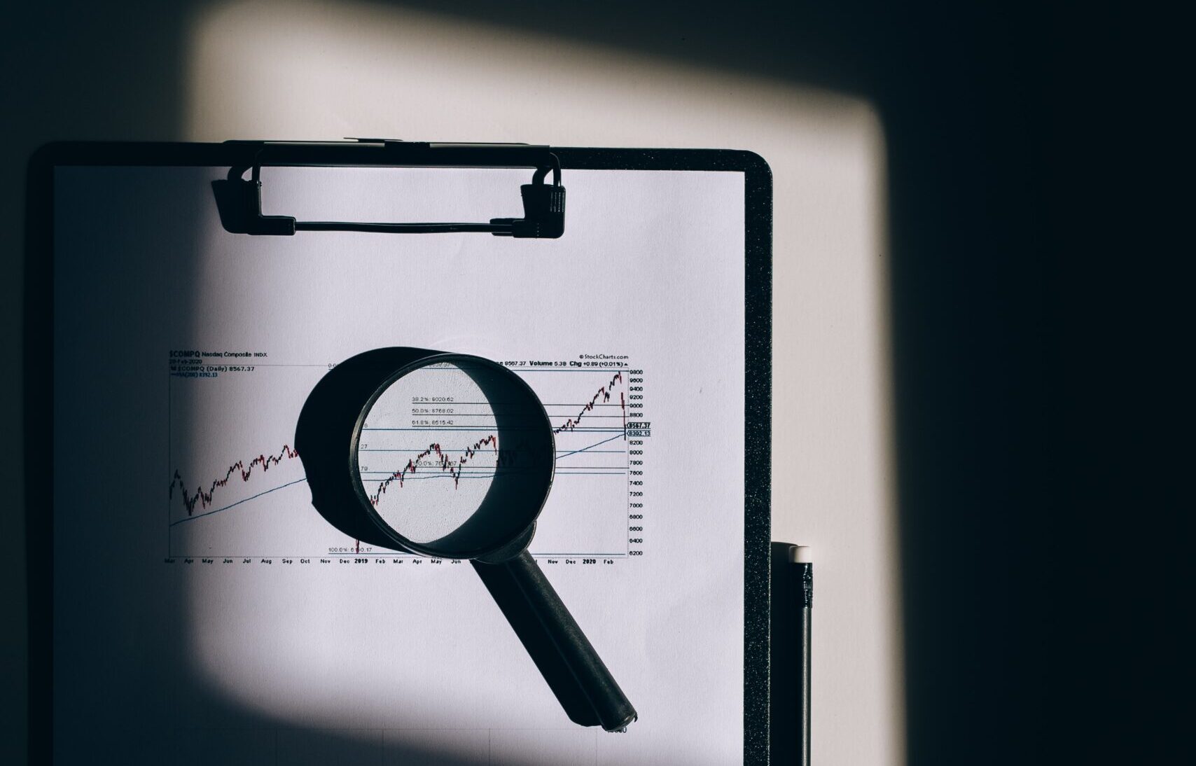 magnifying glass laying on top of chart on clipboard