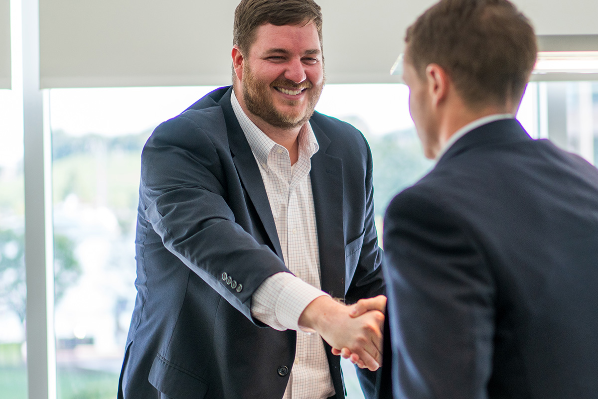 two guys in suites shaking hands